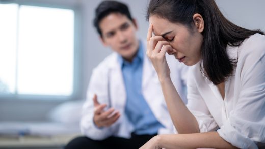 Mulher chorando e expressando sofrimento emocional enquanto recebe apoio psicológico no hospital.